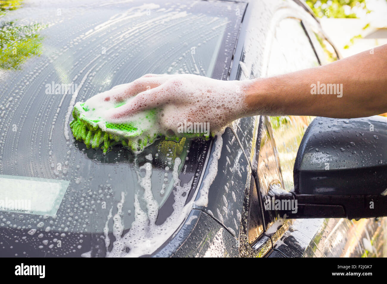 Man with sponge in hand washing car Stock Photo Alamy