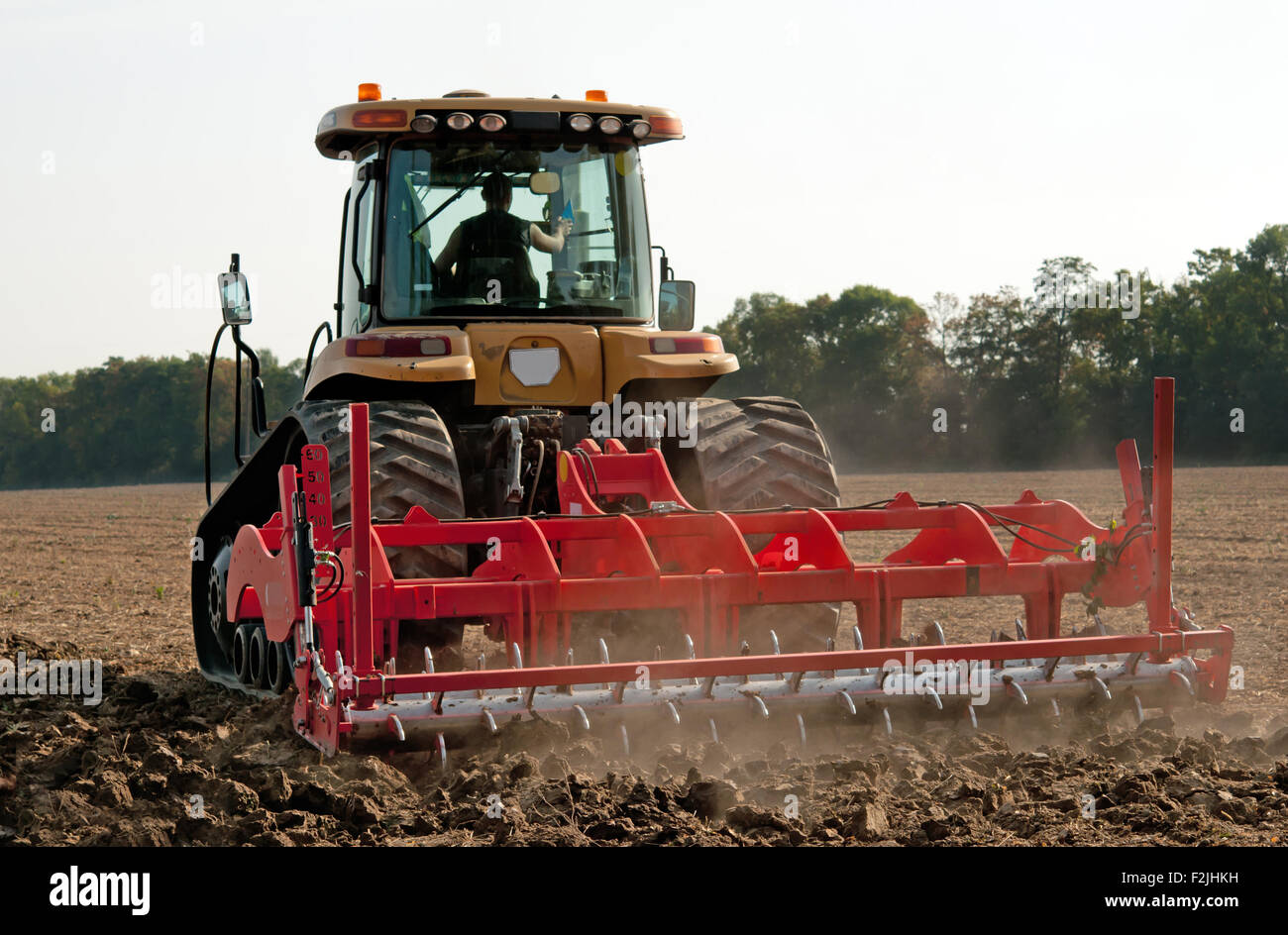 farmer in tractor preparing land with seedbed cultivator Stock Photo