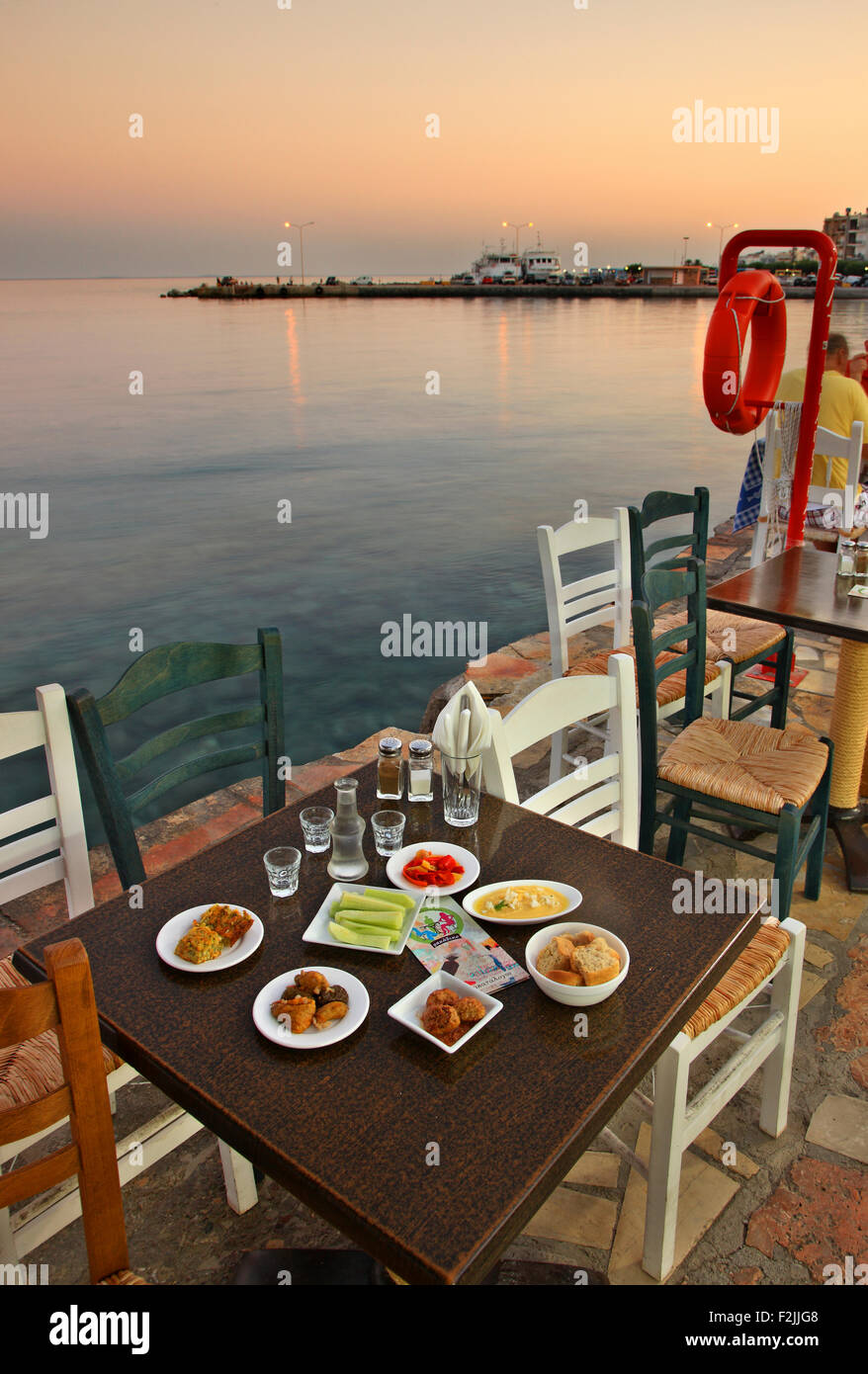 Table with traditional Cretan food and raki, the traditional Cretan drink at a tavern in Ierapetra town, Lasithi, Crete, Greece Stock Photo