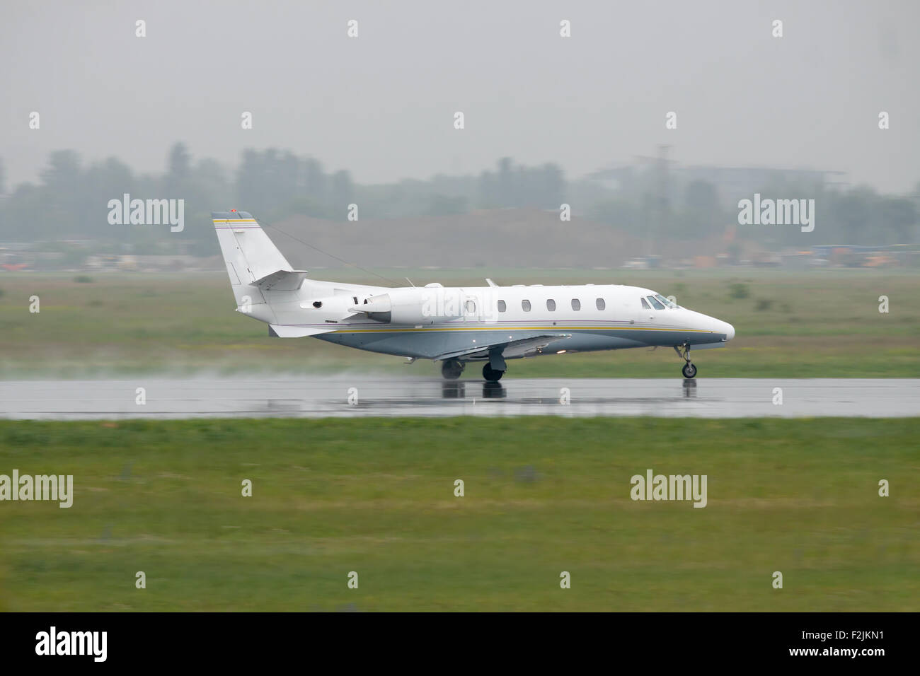 Business jet is taking off from the runway during the rain Stock Photo