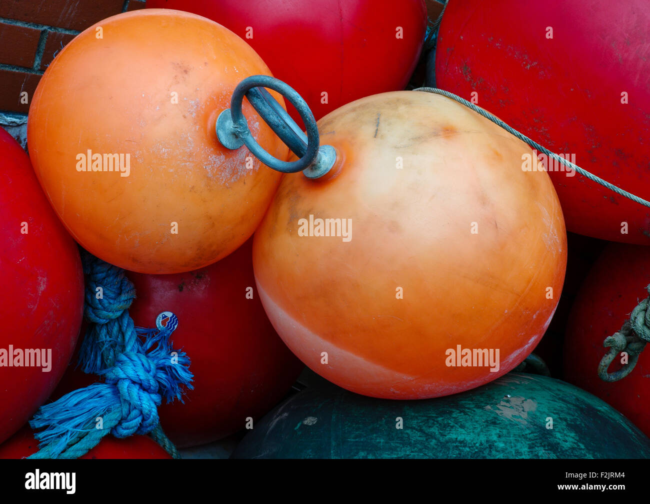 Pair of orange floats in a pile of red floats Stock Photo