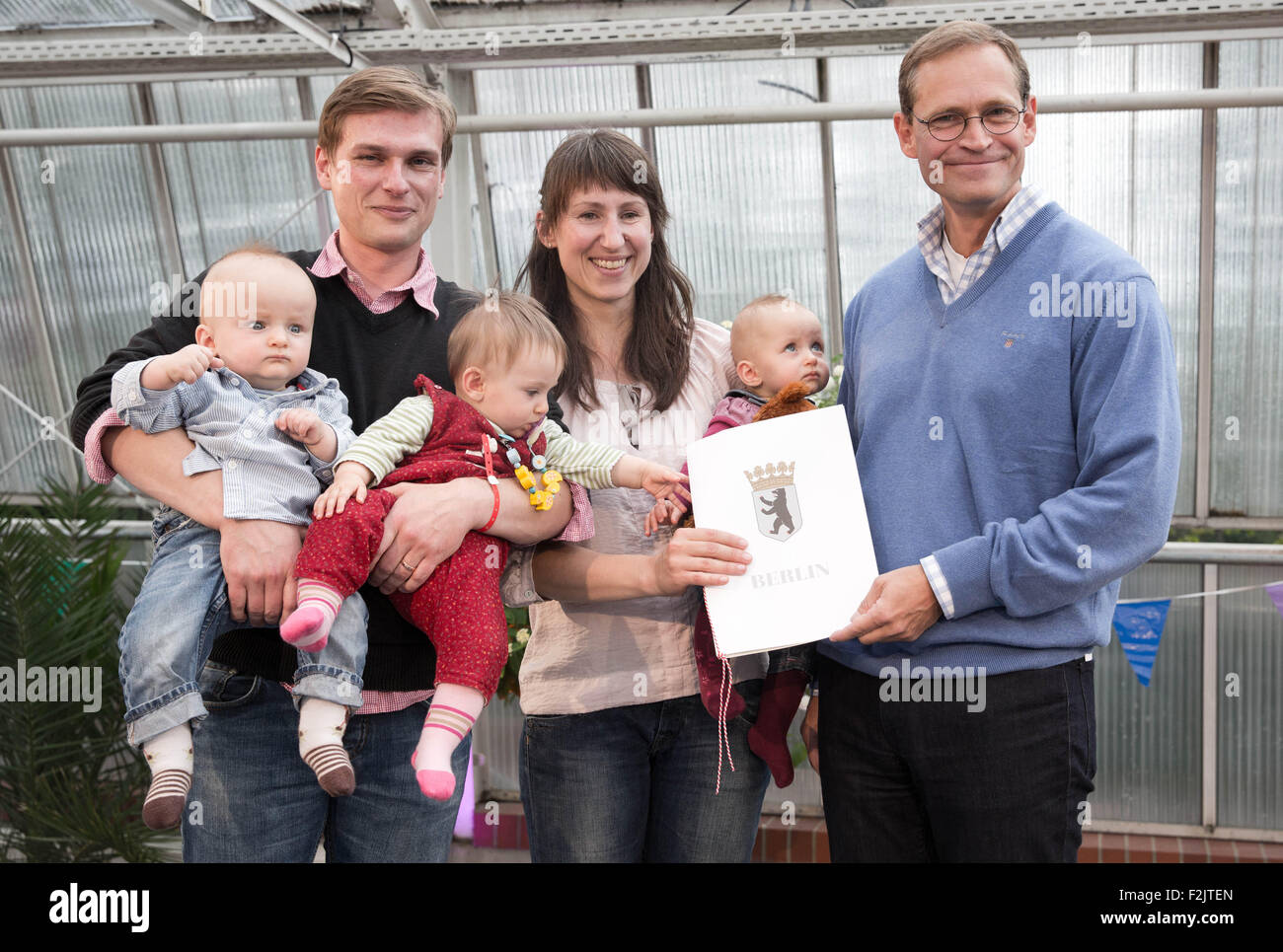 Berlin, Germany. 20th Sep, 2015. Berlin's Governing Mayor Michael Mueller (R) hands a sponsorship certificate to the Ulonska family including the parents Johannes und Marlen and the triplets Karoline Sophie, Emilie Jara and Niklas Elias, in Berlin, Germany, 20 September 2015. Berlin's Governing Mayor has been acting as an honorary sponsor to children from multiple births with more than three babies if the parents agree to it. Photo: Joerg Carstensen/dpa/Alamy Live News Stock Photo