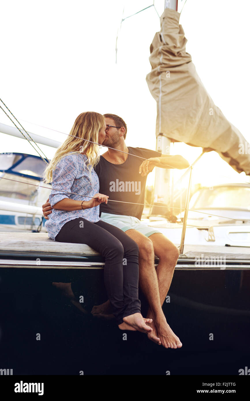 Sweet Young Couple Kissing at the Yacht Deck During Sunset Time. Stock Photo