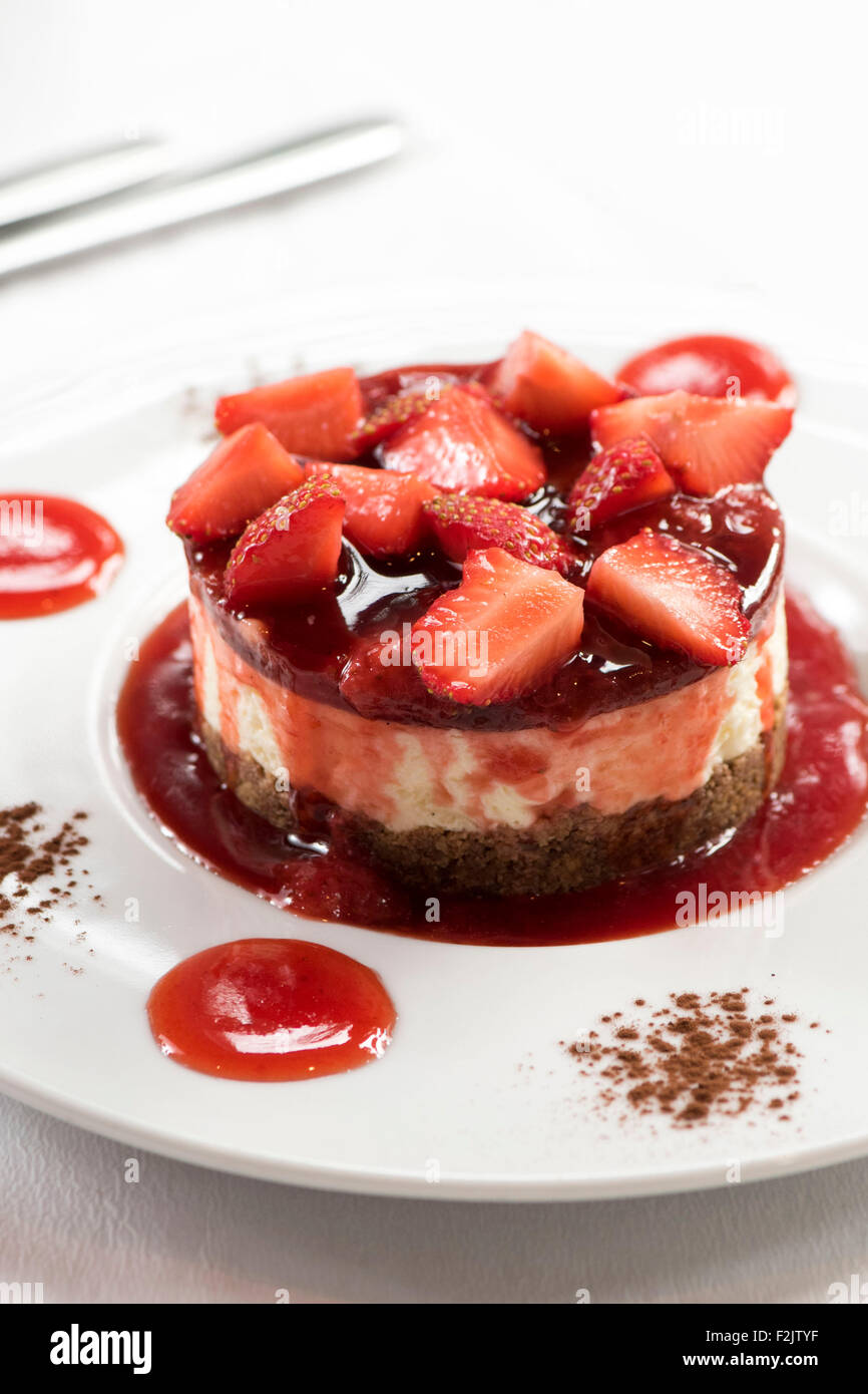 A red strawberry cheesecake dessert served at an italian restaurant. Stock Photo