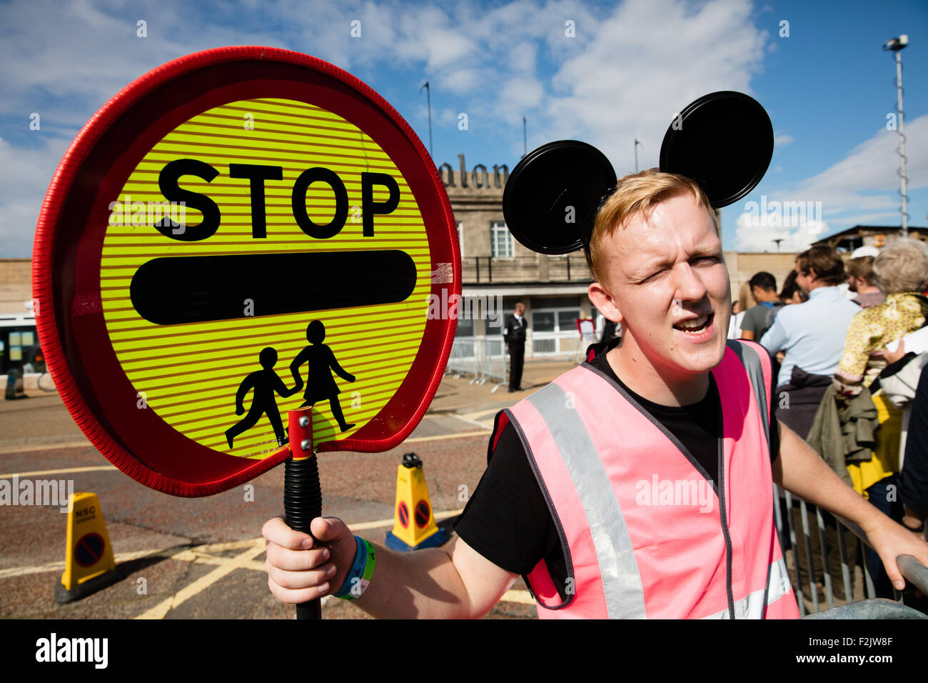 A mouse eared lollipop man herding visitors across the road to Banksy's Dismaland theme park attraction in Weston super Mare UK Stock Photo