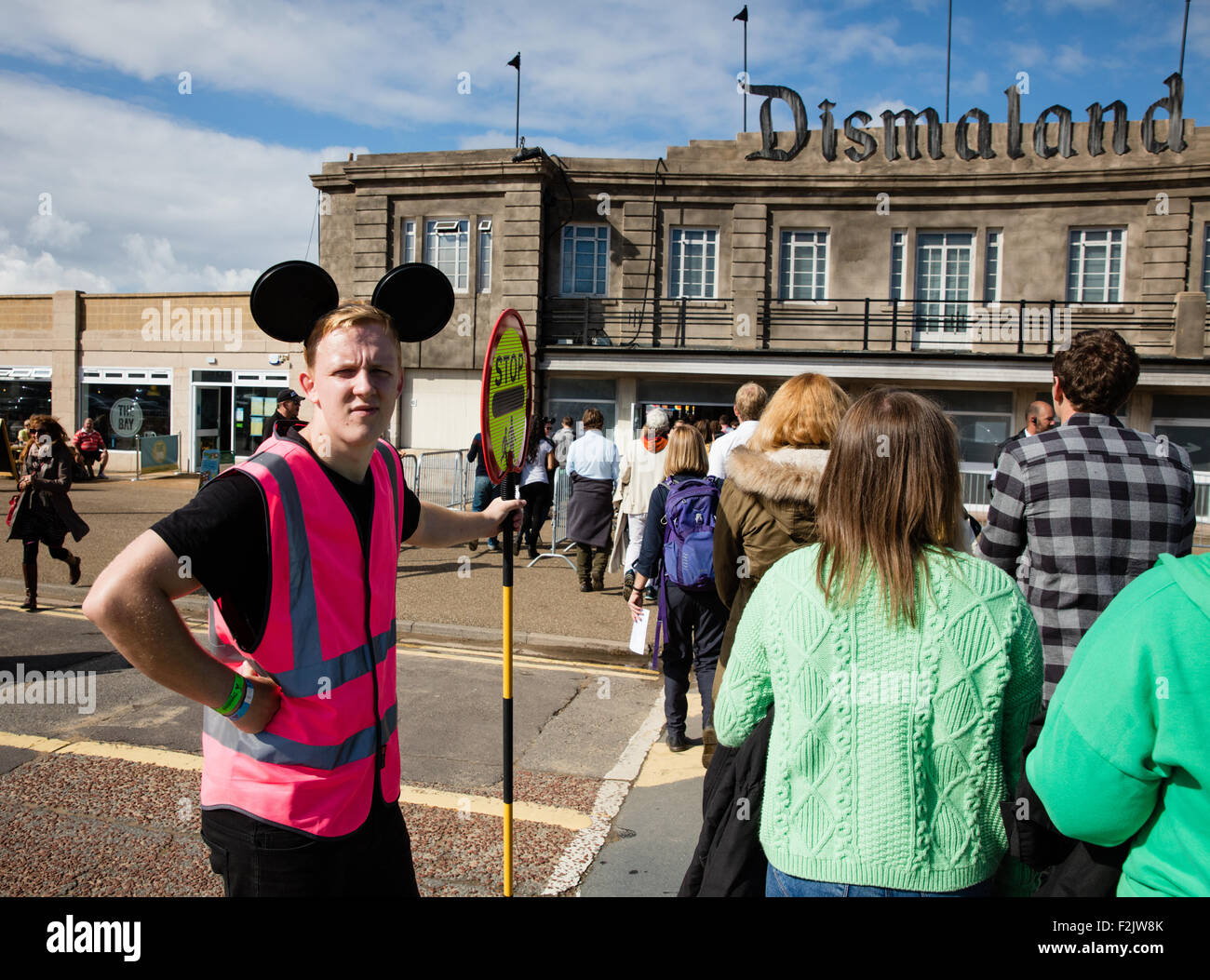 An impatient lollipop man wearing mickey mouse ears the public
