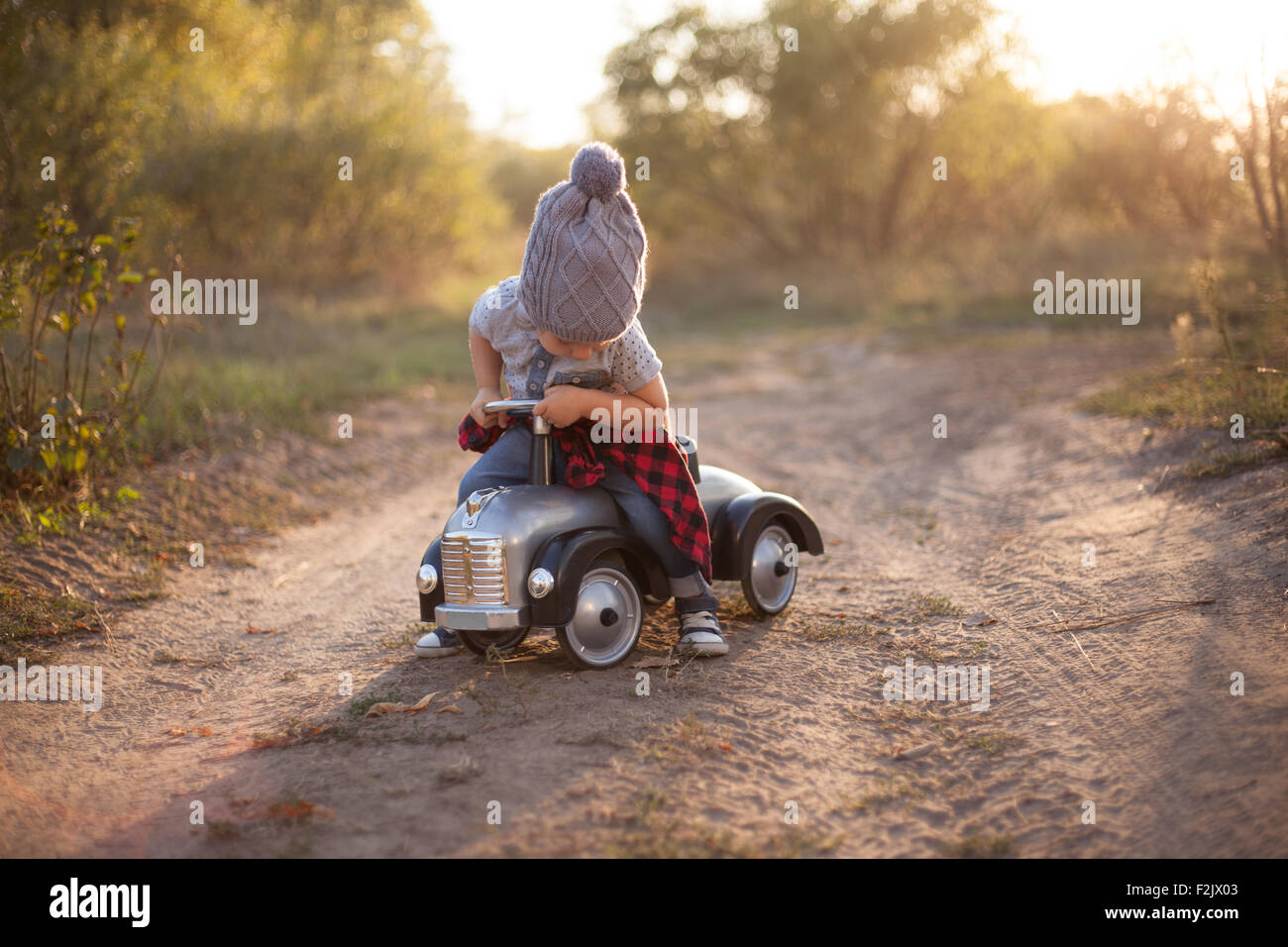 Toddler driving toy car outdoors Stock Photo Alamy