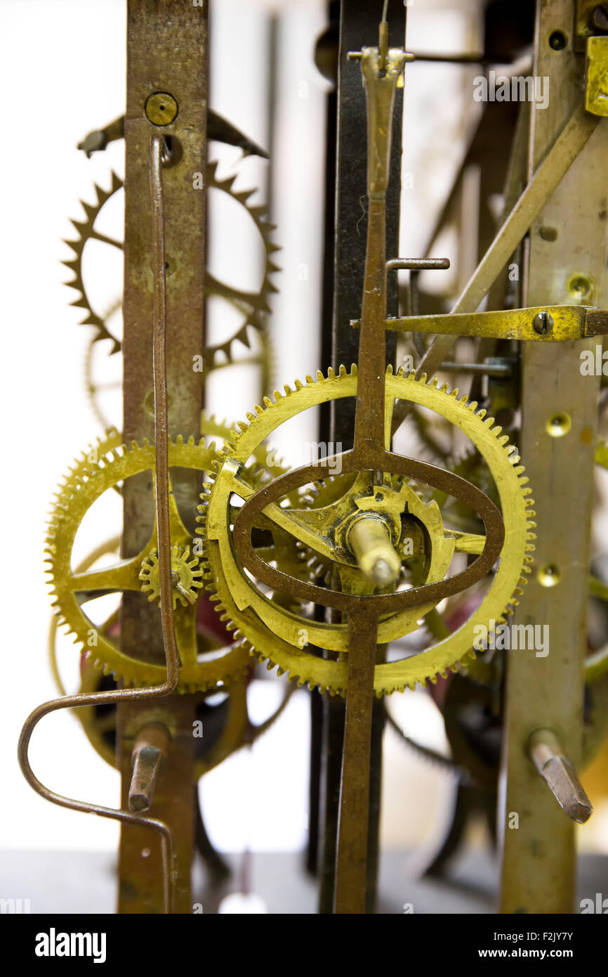 Close up view of greasy and rusty old wall clock mechanism with gears, isolated on white background Stock Photo