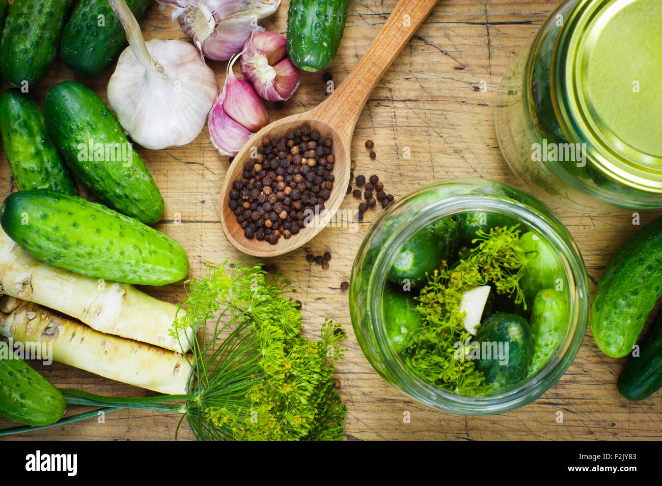 Preparations to make homemade pickles with garlic, dill and horseradish on woodboard Stock Photo