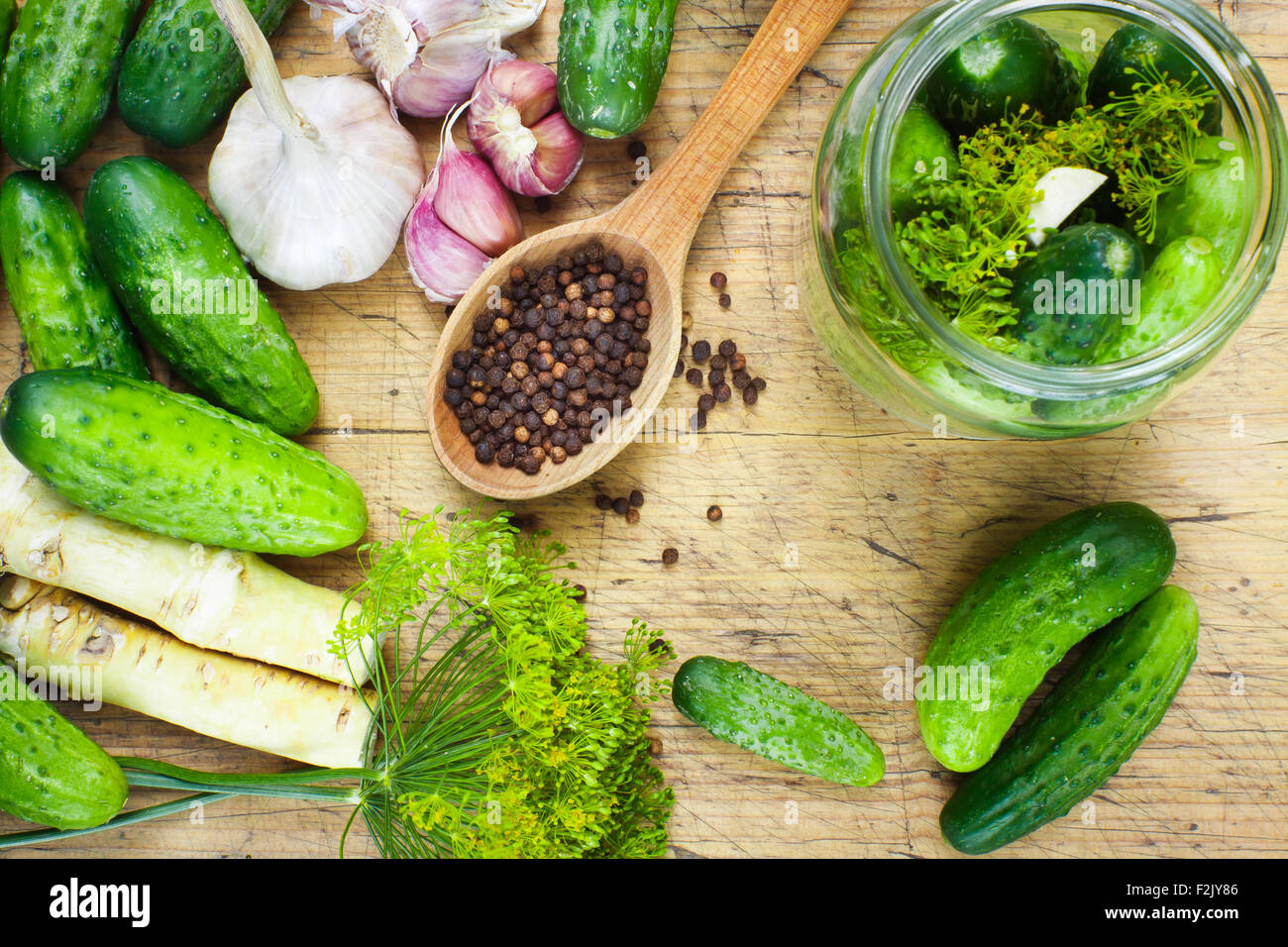 Preparations to make homemade pickles with garlic, dill and horseradish on woodboard Stock Photo