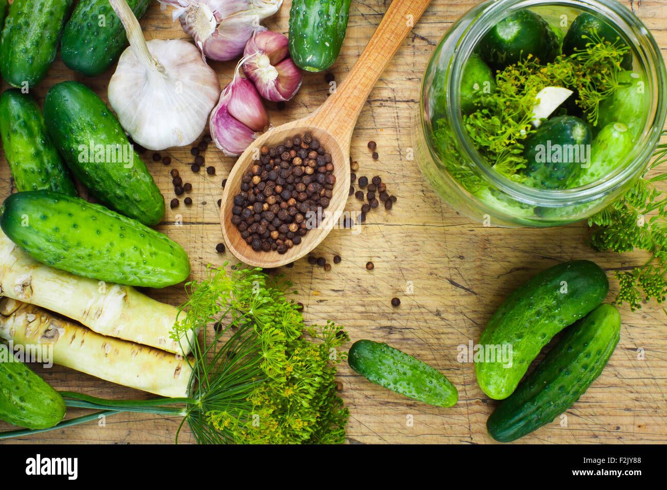 Preparations to make homemade pickles with garlic, dill and horseradish on woodboard Stock Photo