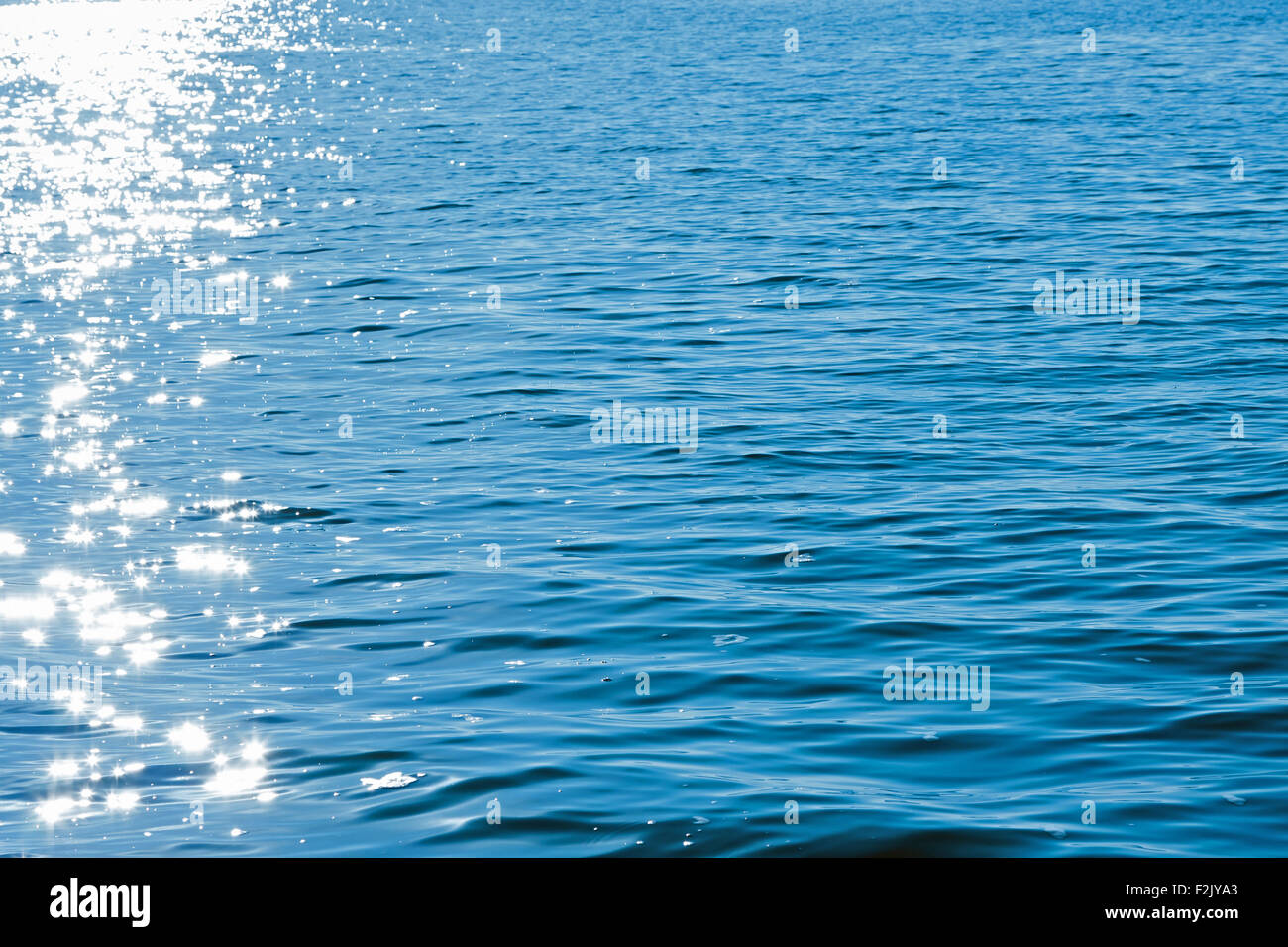 Sun reflexes in blue water as texture or background Stock Photo