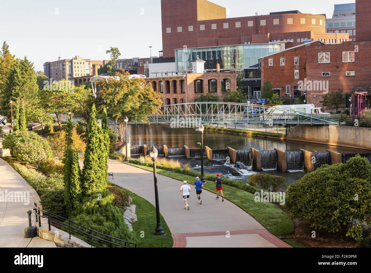 Runners along the Swamp Rabbit Trail at Art Crossing River Place on the Reedy River in downtown Greenville, South Carolina. Stock Photo