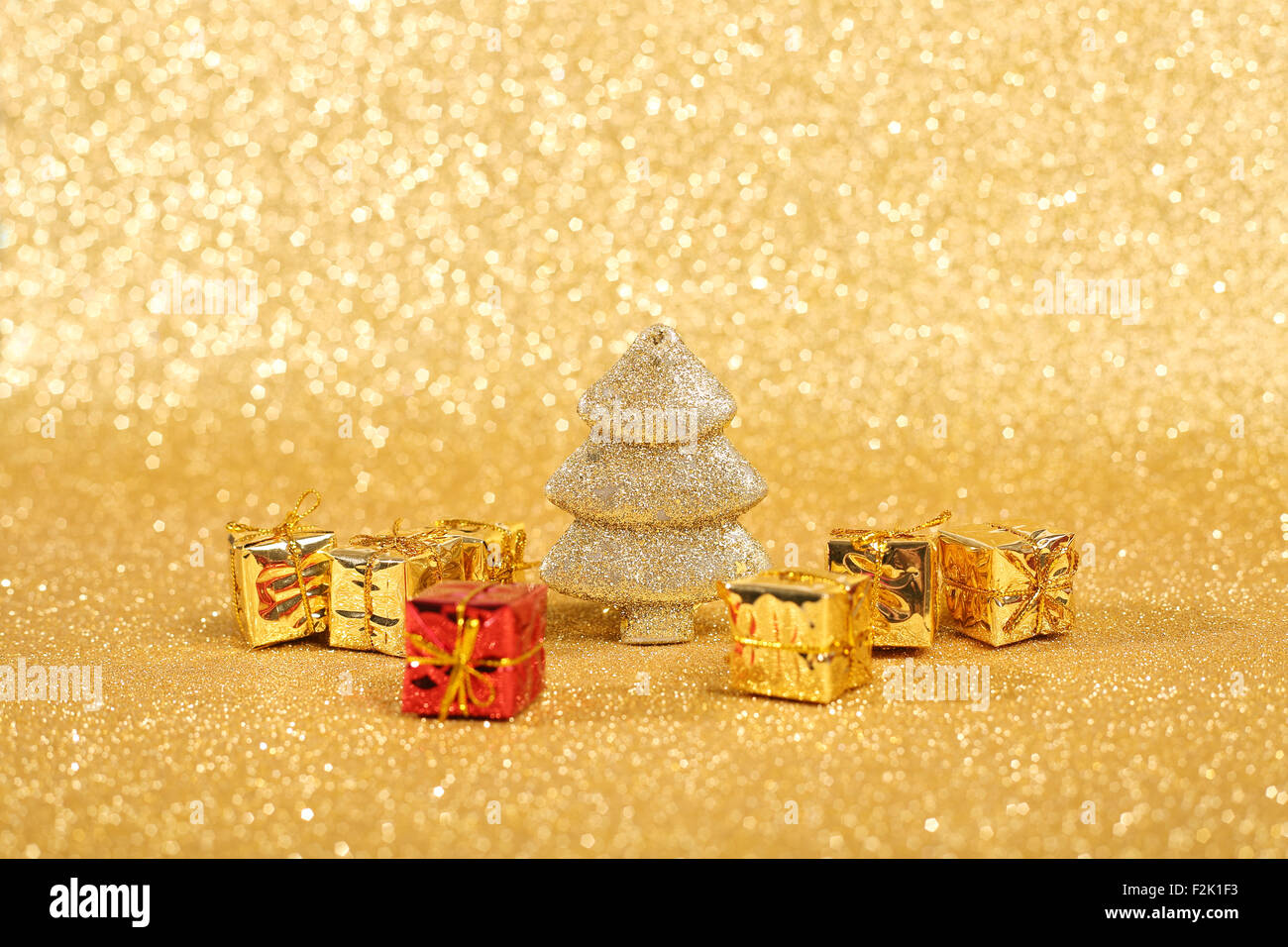 Golden christmas fir tree and gifts decoration on glitter background ...