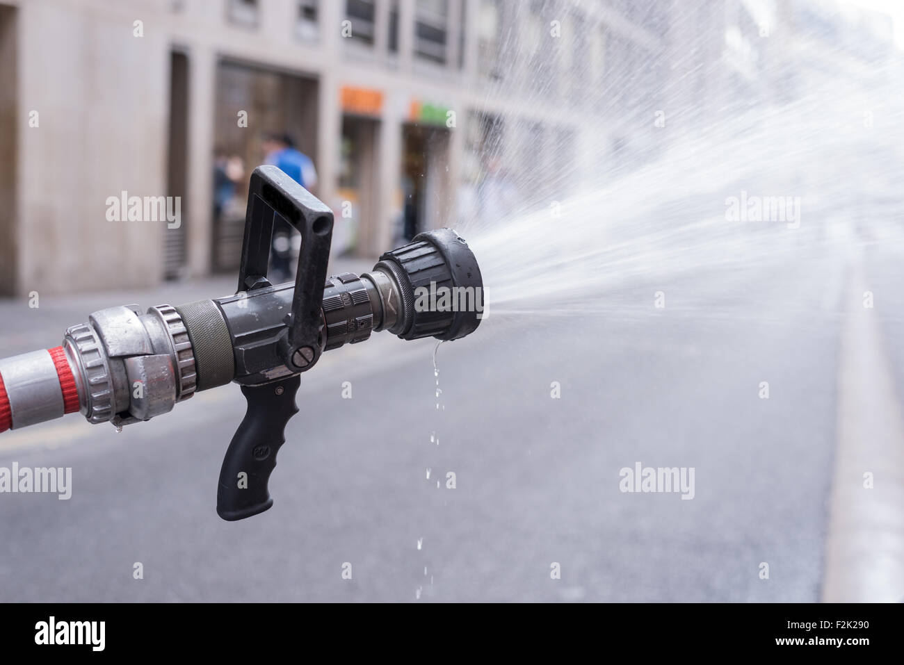 Water jet splashing from a fire fighting firehose nozzle Stock Photo