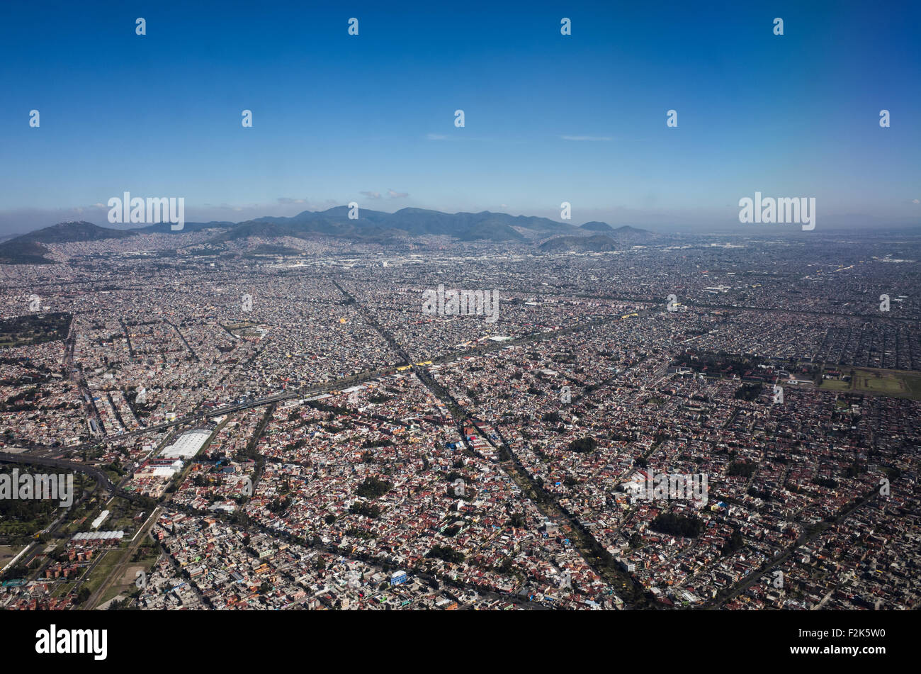 Mexico Aerial View Landscape // An aerial view of Mexico unfolds beneath the plane, revealing a diverse tapestry of landscapes. From rugged mountain ranges and sprawling deserts to lush forests and winding coastlines, this bird's-eye perspective showcases the country's rich geographical variety. Cities and rural areas alike punctuate the terrain, offering a stunning visual representation of Mexico's natural beauty and human development. Stock Photo