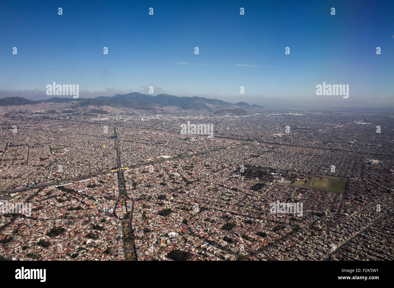 Mexico Aerial View Landscape Mexico // An aerial view of Mexico unfolds beneath the plane, revealing a diverse tapestry of landscapes. From rugged mountain ranges and sprawling deserts to lush forests and winding coastlines, this bird's-eye perspective showcases the country's rich geographical variety. Cities and rural areas alike punctuate the terrain, offering a stunning visual representation of Mexico's natural beauty and human development. Stock Photo