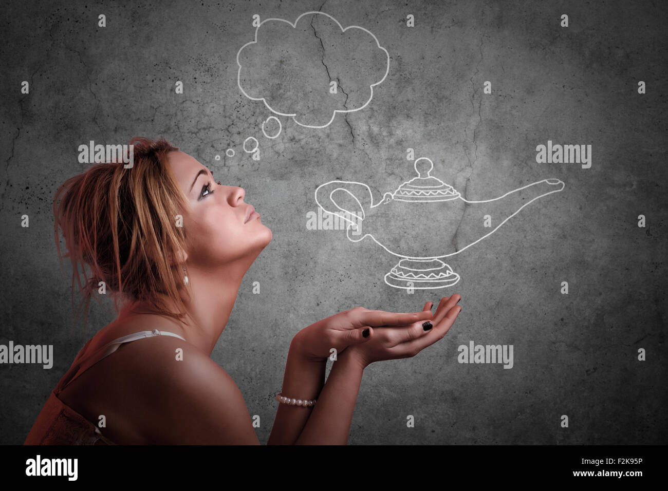Girl expressing desire while looking the Aladin lamp Stock Photo