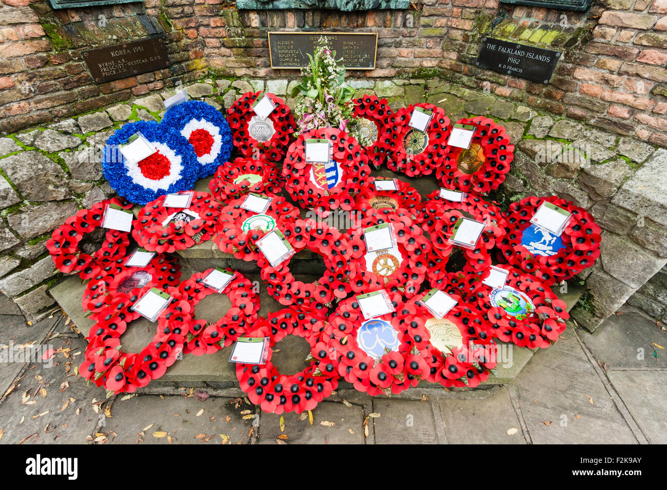 Remembrance Sunday in Britain in November to commemorate the dead of both world wars and other conflicts. Wreaths of poppies in front of war memorial. Stock Photo