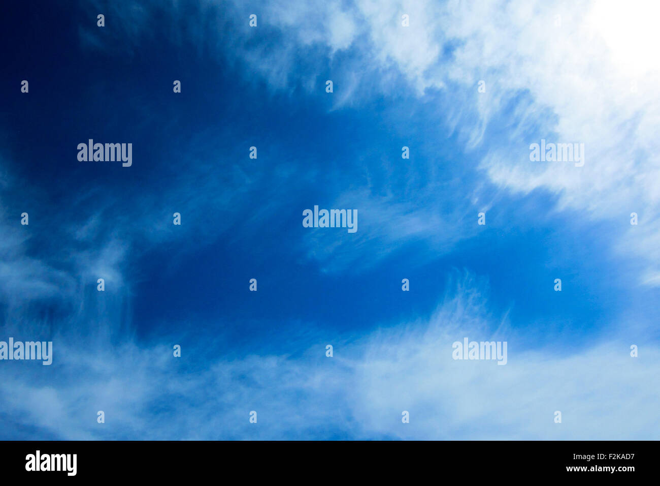 Brilliant blue sky with light scattered clouds. Stock Photo