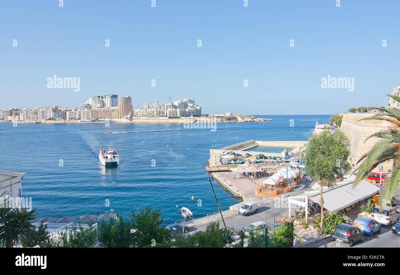 Sliema skyline and ferry en route from Sliema to Valletta ferry terminal on a sunny summer day in September. Stock Photo