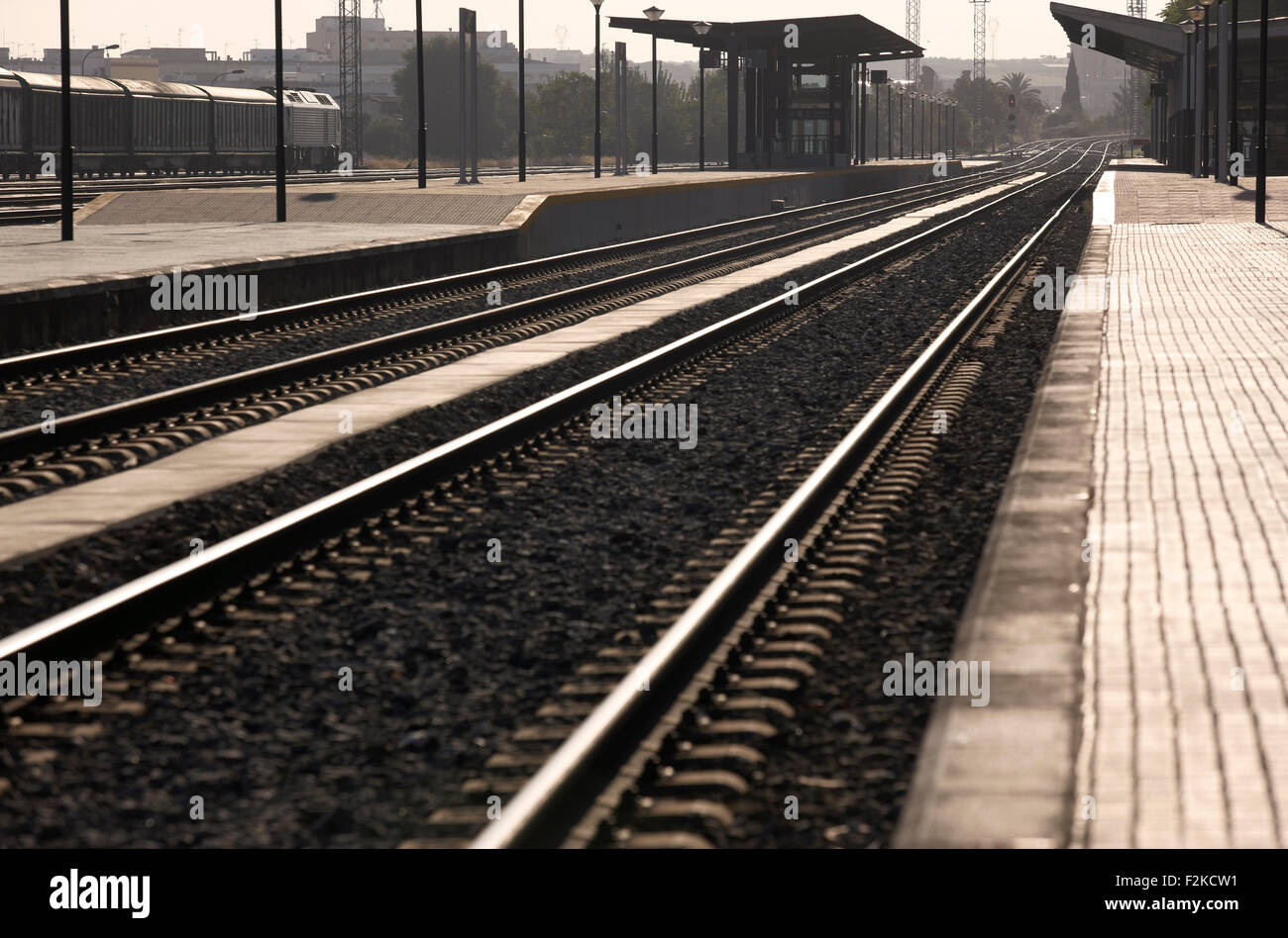 Railway station platforms and rails at sunset Stock Photo