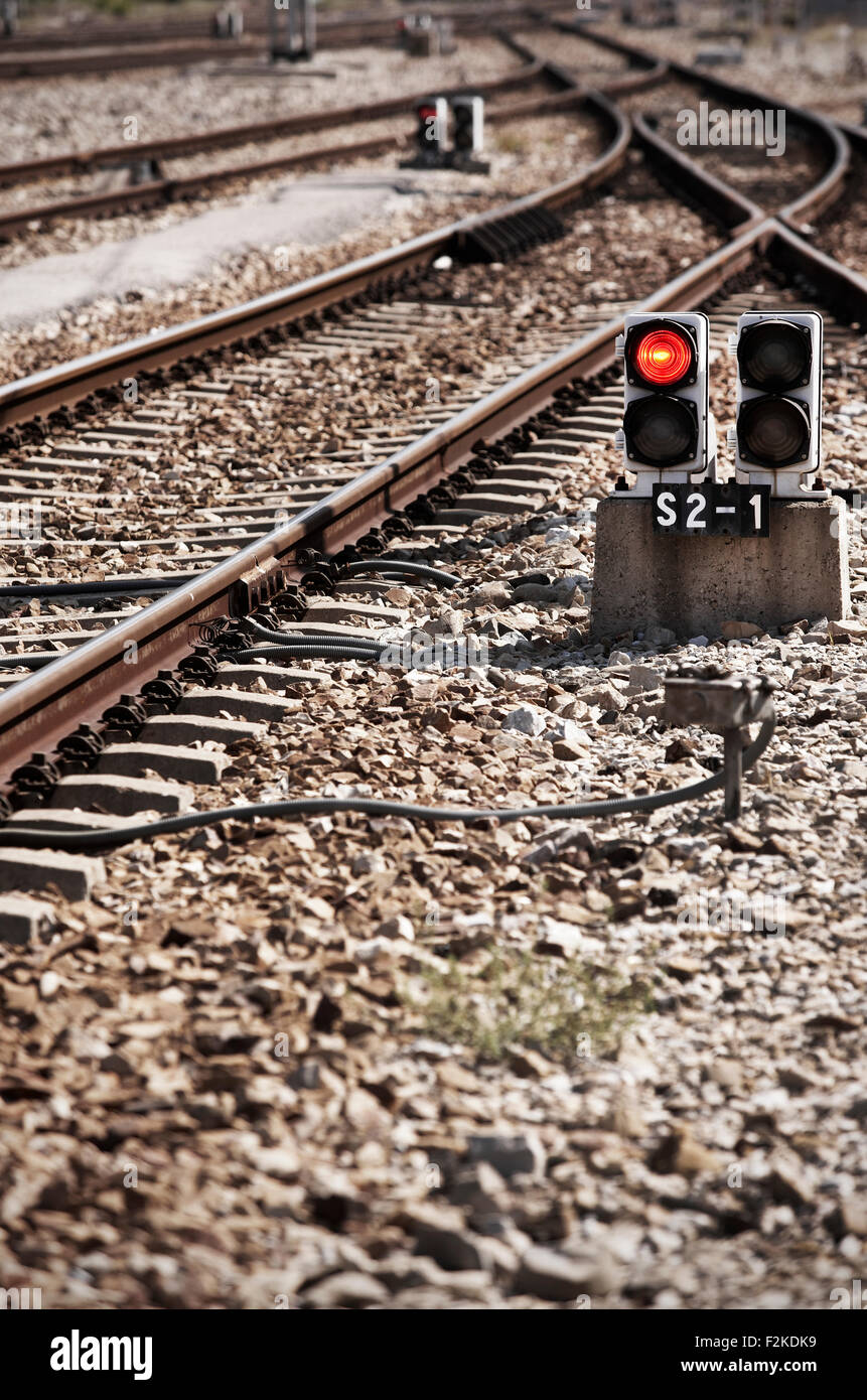 Railway line with red light alert vertical Stock Photo - Alamy