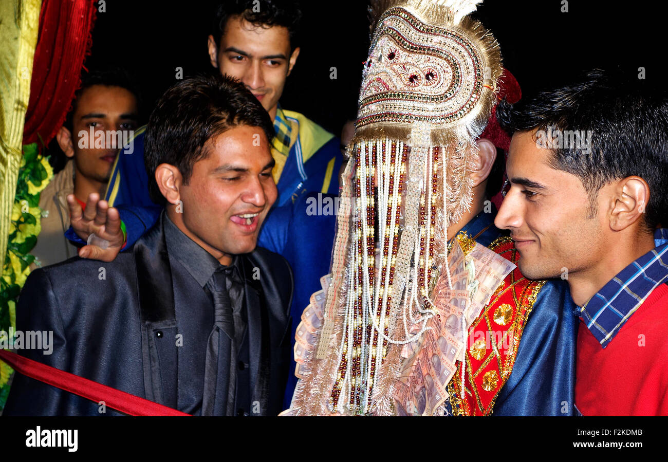 Groom cutting red tape at traditional wedding ceremony Stock Photo