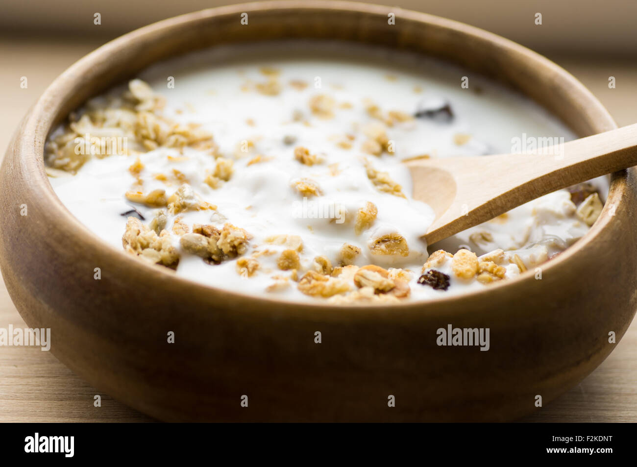 Muesli with fruit and nuts and milk in a wooden bowl rustic style Stock