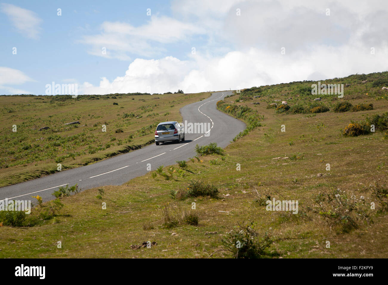 Car driving over moorland road near Haytor, Dartmoor national park, Devon, England, UK Stock Photo