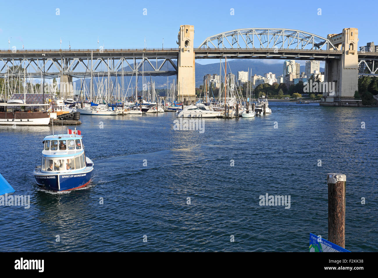 Burrard Street Bridge in Vancouver Canada from Granville Island with a water bus in the foreground Stock Photo