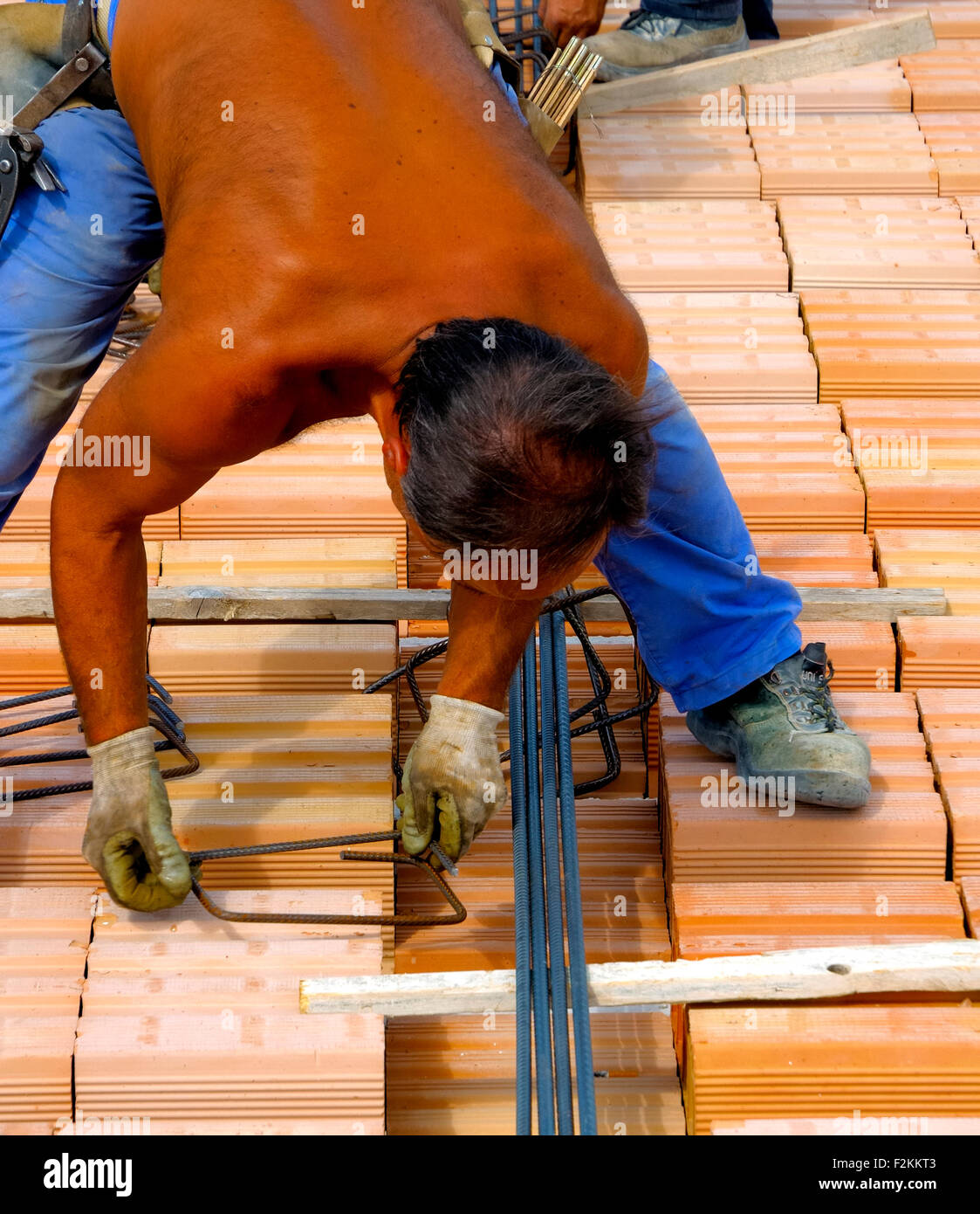 worker in workwear making reinforcement metal framework for concrete ...