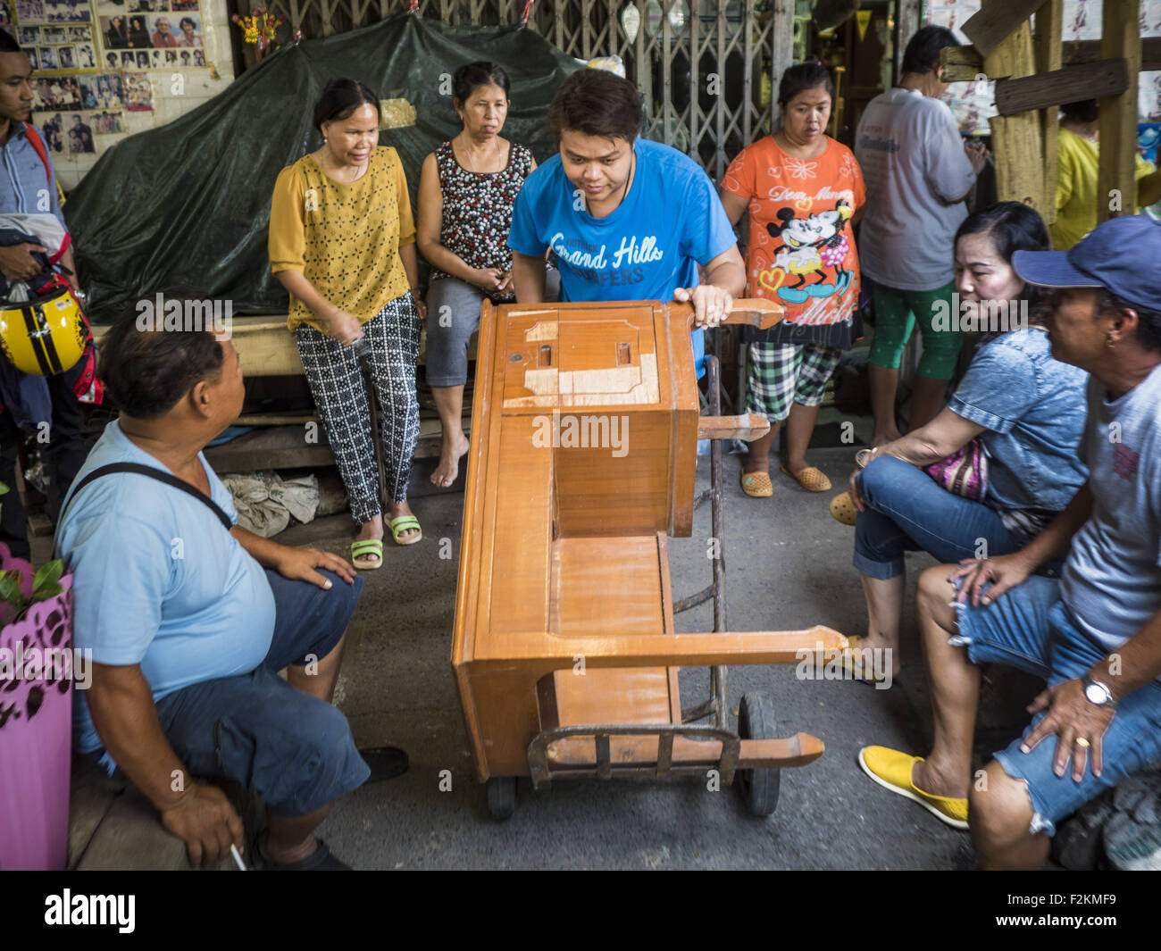 Bangkok, Thailand. 21st Sep, 2015. A neighborhood resident being evicted from his home near Wat Kalayanamit wheels his desk past neighbors while he packs. Fiftyfour homes around Wat Kalayanamit, a historic Buddhist temple on the Chao Phraya River in the Thonburi section of Bangkok are being razed and the residents evicted to make way for new development at the temple. © ZUMA Press, Inc./Alamy Live News Stock Photo