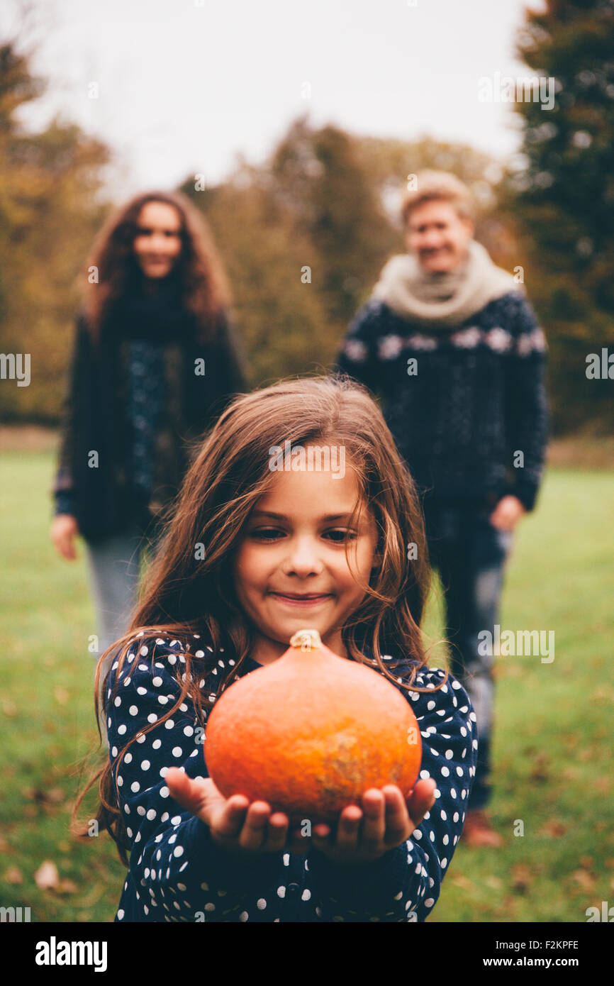 Portrait of smiling little girl showing Hokkaido pumpkin while her ...