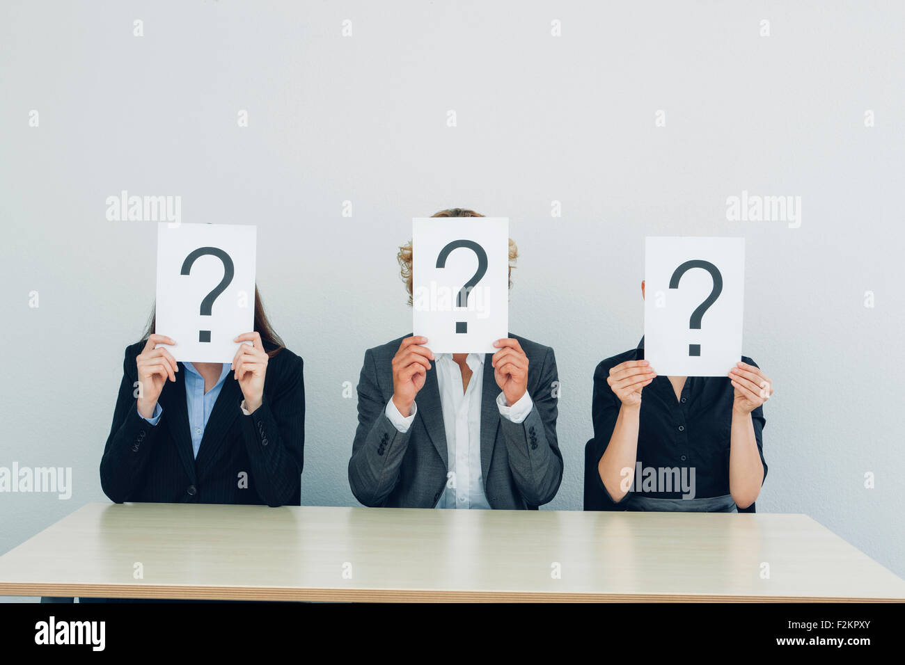 Business people with question mark on placards Stock Photo