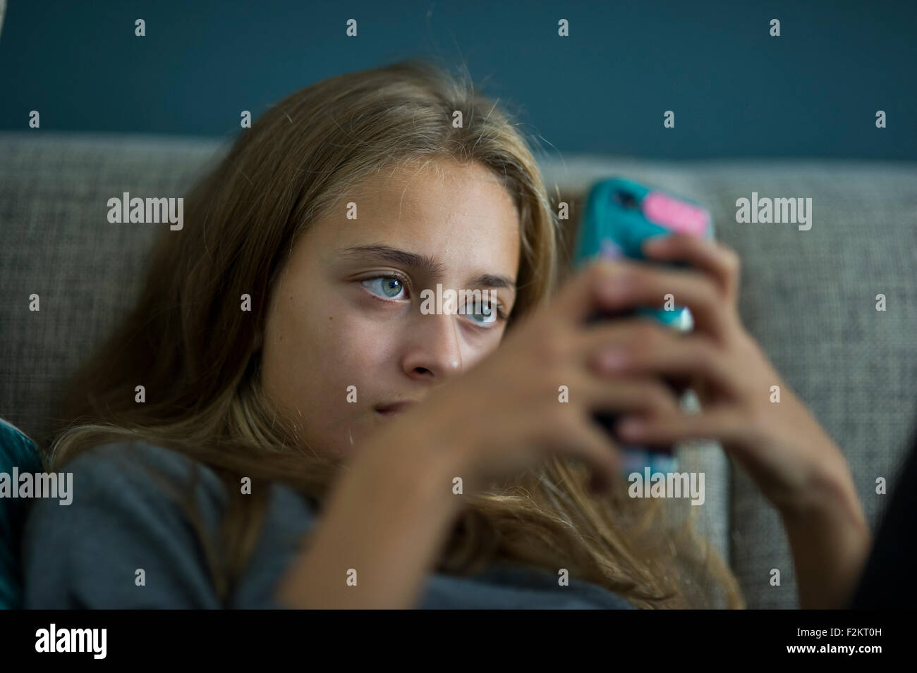 Young girl relax with her smartphone on a sofa Stock Photo