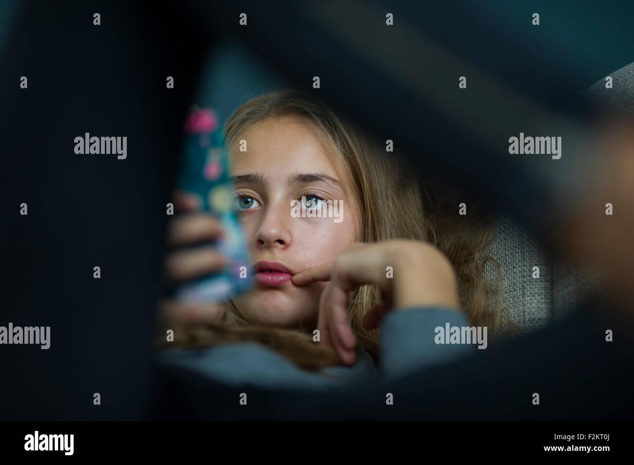 Young girl relax with her smartphone on a sofa Stock Photo