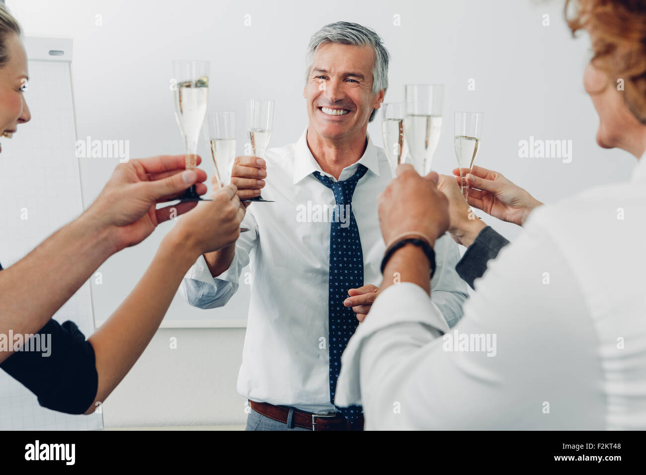 Group of business people raising a toast with champagne at office Stock
