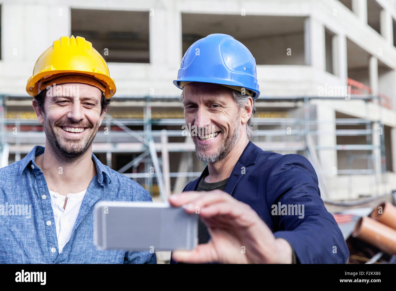 Two happy men on construction site taking a selfie Stock Photo - Alamy