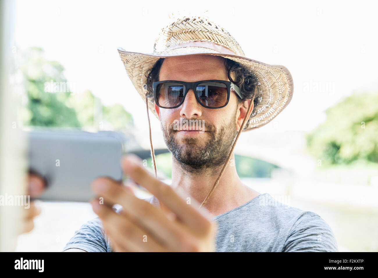 Man wearing straw hat and sunglasses taking a selfie Stock Photo - Alamy
