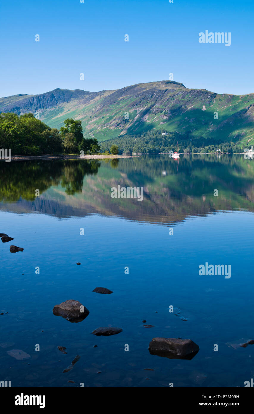 Fells reflected in Derwentwater, calm sunny summer's day, Lake District, Cumbria, England UK Stock Photo