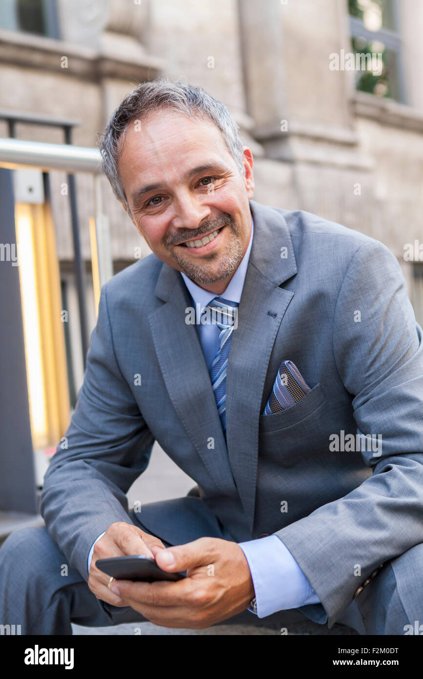 Portrait of smiling businessman wearing grey suit Stock Photo - Alamy