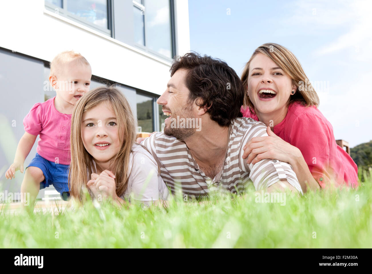 Happy family lying on lawn Stock Photo - Alamy