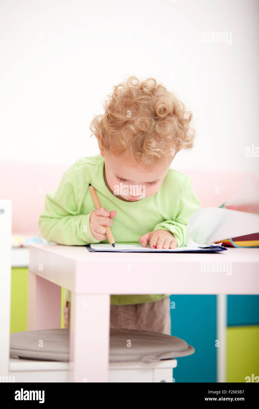 Little blond girl painting with coloured pencil Stock Photo - Alamy