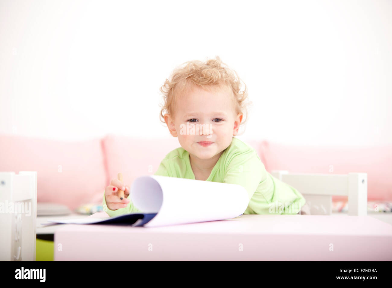 Portrait of little blond girl with coloured pencil Stock Photo