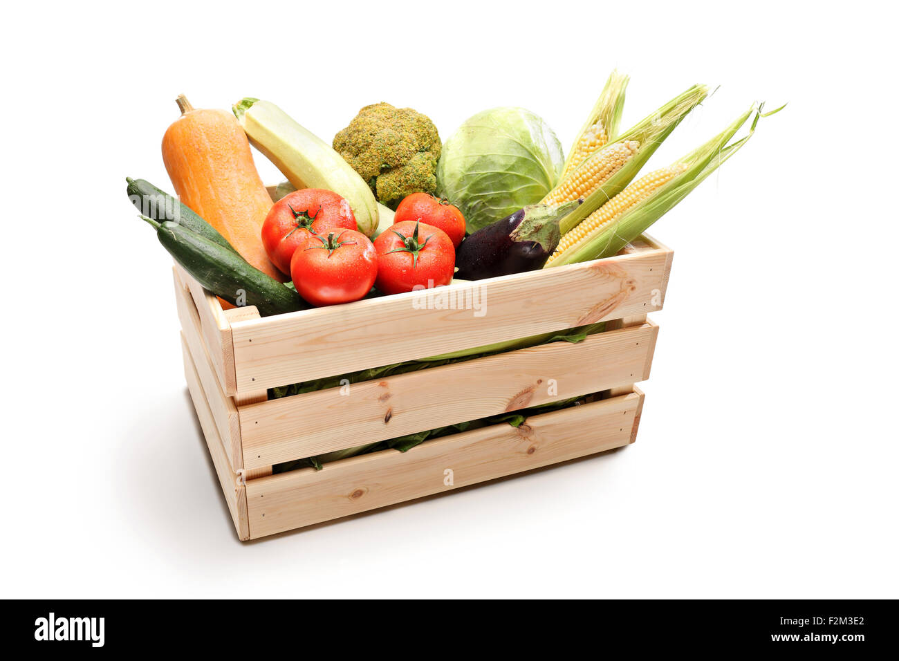 Studio shot of a wooden crate full of different types of fresh vegetables isolated on white background Stock Photo