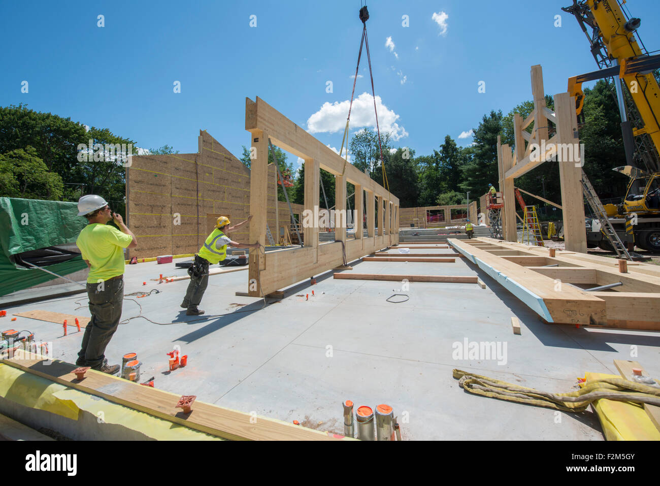 16,000 pound wooden engineered timber trusses await installation by crane for Leed Platinum Common Ground High School building. Stock Photo