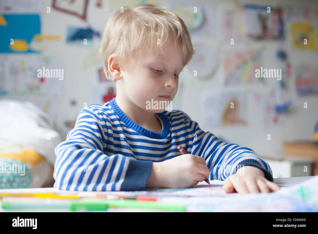 Portrait of blond little boy painting with crayon Stock Photo