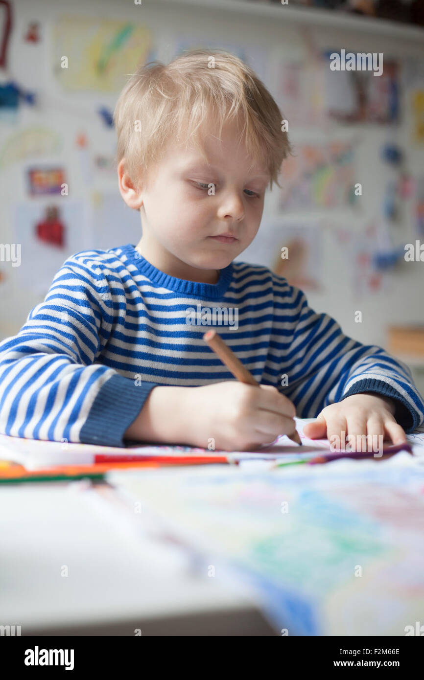 Portrait of blond little boy painting with crayon Stock Photo
