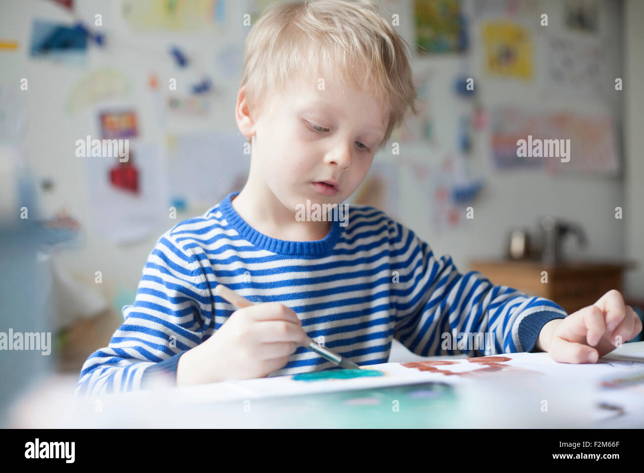Portrait of blond little boy painting with watercolours Stock Photo